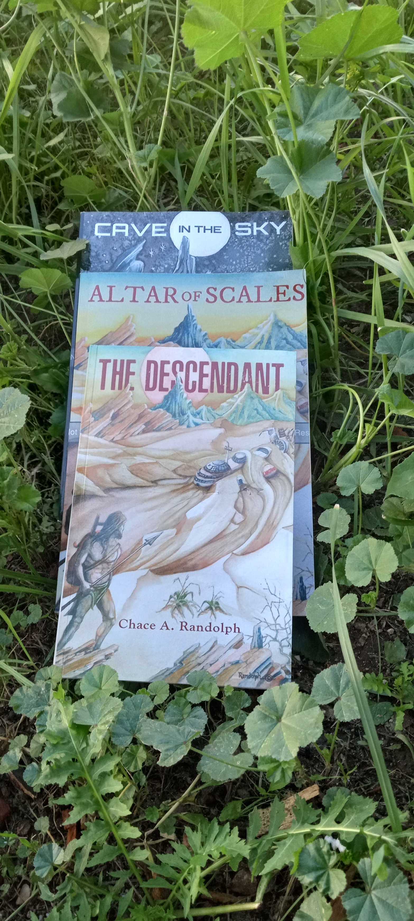 The sci-fi novels of Author Chace Randolph. Book 2,Cave in the Sky, second edition of book one Altar of Scales and first edition of book one The Descendant.